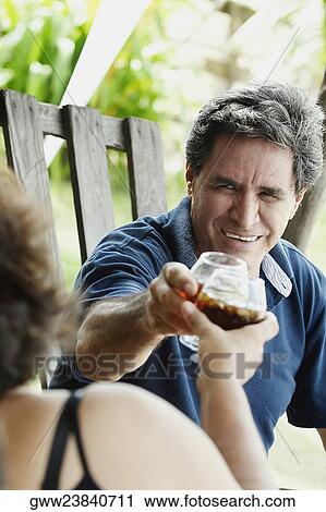 Close-up of a mature couple toasting with wine glasses View Large Photo Image Stock Image - Close-up of a mature couple toasting with wine glasses. Fotosearch