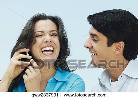 Close-up of a mature woman talking on a mobile phone with a mid adult man smiling beside her View Large Photo Image Stock Image - Close-up of a mature woman talking on a mobile phone with a mid adult man smiling beside her. Fotosearch