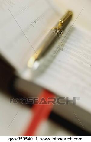Stock Image - Close-up of a metal pen on a diary. Fotosearch