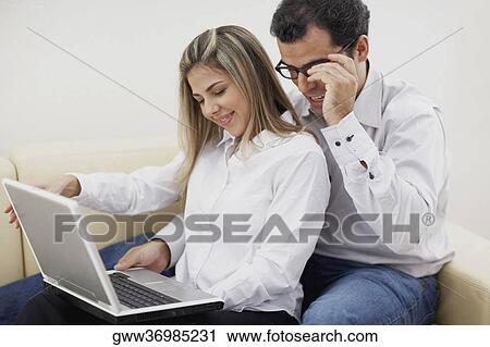 Close-up of a mid adult couple using a laptop View Large Photo Image Stock Image - Close-up of a mid adult couple using a laptop. Fotosearch