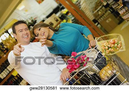 Stock Image - Close-up of a mid adult man and a young woman in a supermarket. Fotosearch