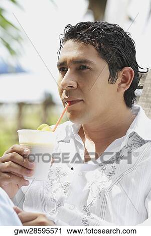Close-up of a mid adult man drinking a glass of juice View Large Photo Image Stock Image - Close-up of a mid adult man drinking a glass of juice. Fotosearch