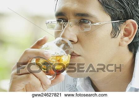 Stock Image - Close-up of a mid adult man drinking wine. Fotosearch