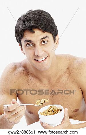 Stock Image - Close-up of a mid adult man holding a bowl of cereal. Fotosearch