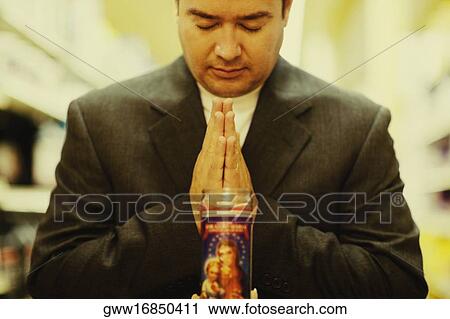 Stock Image - Close-up of a mid adult man praying. Fotosearch