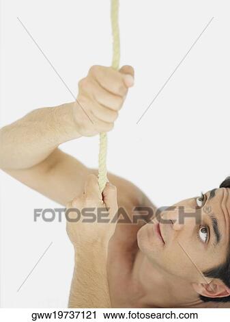 Close-up of a mid adult man pulling a rope View Large Photo Image Stock Image - Close-up of a mid adult man pulling a rope. Fotosearch