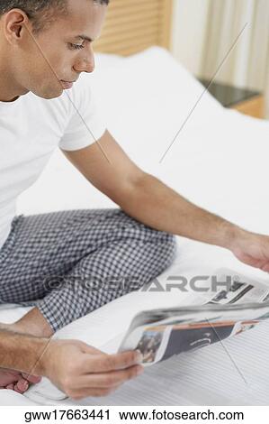 Stock Image - Close-up of a mid adult man reading a newspaper. Fotosearch