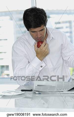 Stock Image - Close-up of a mid adult man reading a newspaper. Fotosearch