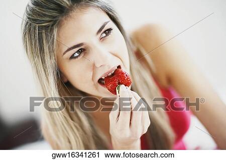 Close-up of a mid adult woman eating a strawberry View Large Photo Image Stock Image - Close-up of a mid adult woman eating a strawberry. Fotosearch