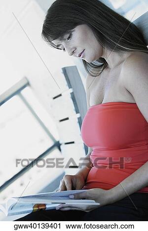 Stock Image - Close-up of a mid adult woman reading a book. Fotosearch