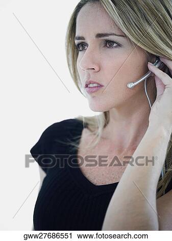 Close-up of a mid adult woman wearing a headset and looking serious View Large Photo Image Stock Image - Close-up of a mid adult woman wearing a headset and looking serious. Fotosearch