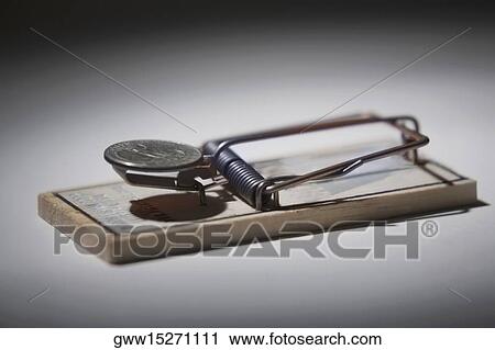 Stock Image - Close-up of a mousetrap with a coin. Fotosearch
