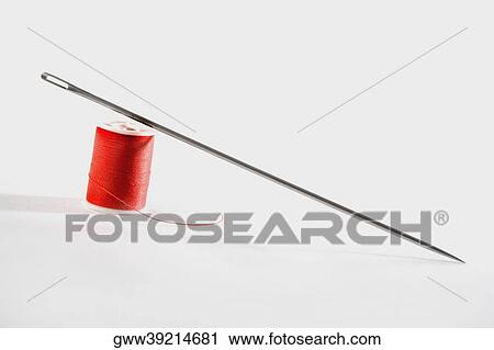 Stock Image - Close-up of a needle with a spool of thread. Fotosearch