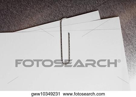 Stock Image - Close-up of a paper clip on sheets of paper. Fotosearch