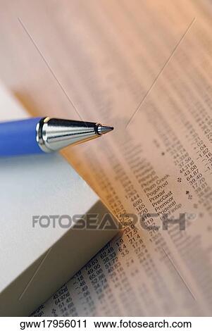 Stock Image - Close-up of a pen and diary on stock market data. Fotosearch