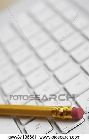 Close-up of a pencil on a laptop's keyboard View Large Photo Image Stock Image - Close-up of a pencil on a laptop's keyboard. Fotosearch