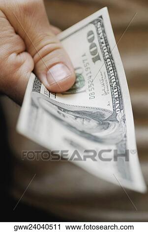Close-up of a person's hand holding one hundred dollar bill View Large Photo Image Stock Image - Close-up of a person's hand holding one hundred dollar bill. Fotosearch