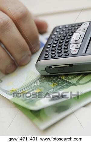 Close-up of a person's hand near one hundred Euro banknotes and a mobile phone View Large Photo Image Stock Image - Close-up of a person's hand near one hundred Euro banknotes and a mobile phone. Fotosearch