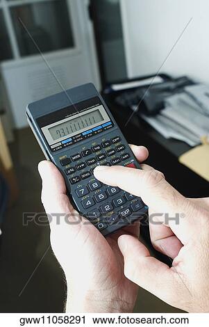 Close-up of a person's hand using a calculator View Large Photo Image Stock Image - Close-up of a person's hand using a calculator. Fotosearch