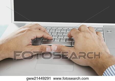 Stock Image - Close-up of a person's hands working on a laptop. Fotosearch
