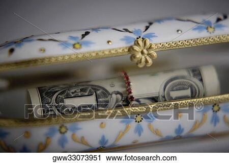 Stock Image - Close-up of a roll of paper currency in a purse. Fotosearch