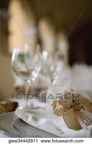 Stock Image - Close-up of a rose shaped bow and a napkin on the table. Fotosearch