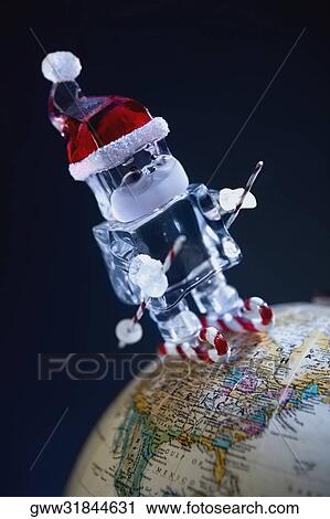 Stock Image - Close-up of a Santa Claus robot on a globe. Fotosearch