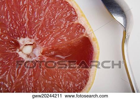 Stock Image - Close-up of a slice of orange and a spoon. Fotosearch