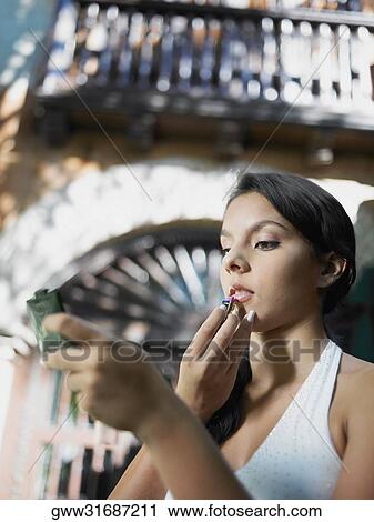 Close-up of a teenage girl applying lipstick on her lips View Large Photo Image Stock Image - Close-up of a teenage girl applying lipstick on her lips. Fotosearch