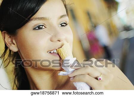 Close-up of a teenage girl eating an ice-cream cone View Large Photo Image Stock Image - Close-up of a teenage girl eating an ice-cream cone. Fotosearch