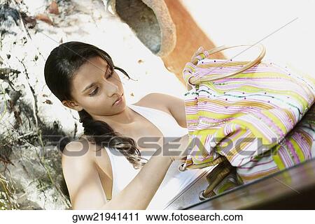 Close-up of a teenage girl looking in her hand bag View Large Photo Image Stock Image - Close-up of a teenage girl looking in her hand bag. Fotosearch