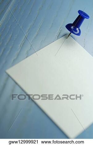 Stock Image - Close-up of a thumbtack on a sheet of paper. Fotosearch