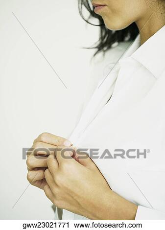 Close-up of a woman buttoning her shirt View Large Photo Image Stock Image - Close-up of a woman buttoning her shirt. Fotosearch
