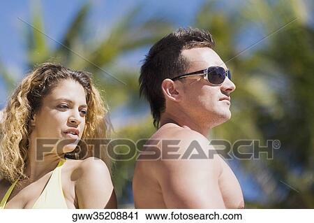 Close-up of a young couple back to back View Large Photo Image Stock Image - Close-up of a young couple back to back. Fotosearch