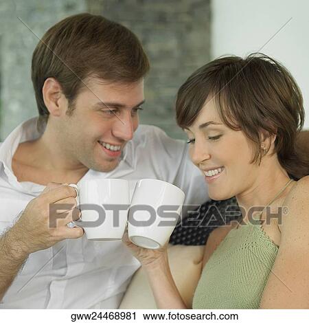 Close-up of a young couple holding coffee cups View Large Photo Image Stock Image - Close-up of a young couple holding coffee cups. Fotosearch