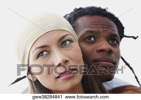 Close-up of a young couple looking away View Large Photo Image Stock Image - Close-up of a young couple looking away. Fotosearch