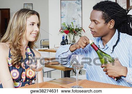 Close-up of a young couple sitting at the table View Large Photo Image Stock Image - Close-up of a young couple sitting at the table. Fotosearch