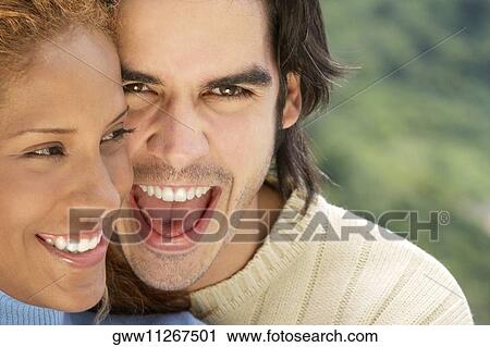 Stock Image - Close-up of a young couple smiling. Fotosearch