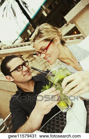 Close-up of a young couple toasting with mojito drinks View Large Photo Image Stock Image - Close-up of a young couple toasting with mojito drinks. Fotosearch