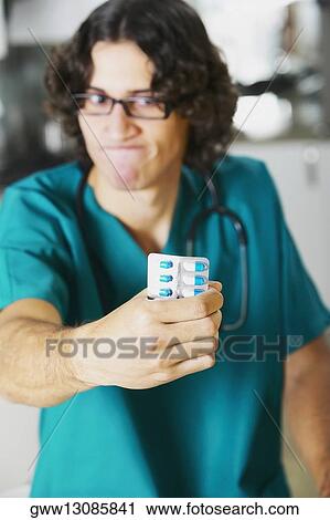 Close-up of a young male doctor holding a blister pack View Large Photo Image Stock Image - Close-up of a young male doctor holding a blister pack. Fotosearch