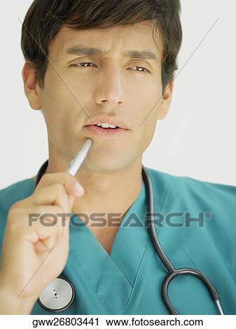 Close-up of a young male doctor thinking View Large Photo Image Stock Image - Close-up of a young male doctor thinking. Fotosearch