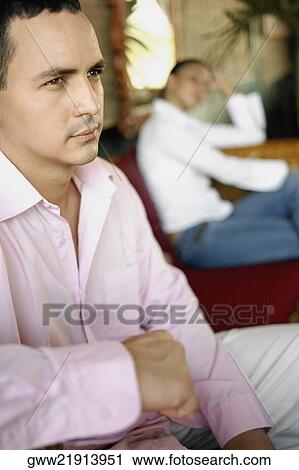 Stock Image - Close-up of a young man and a teenage girl in the background. Fotosearch