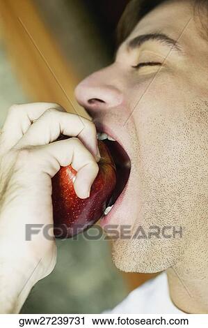 Close-up of a young man eating an apple View Large Photo Image Stock Image - Close-up of a young man eating an apple. Fotosearch