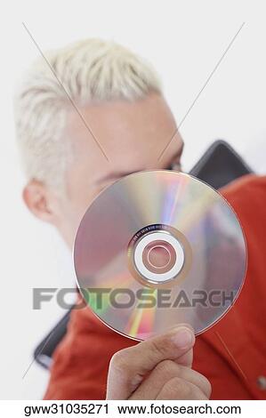Stock Image - Close-up of a young man holding a CD. Fotosearch