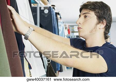 Close-up of a young man in a clothing store View Large Photo Image Stock Image - Close-up of a young man in a clothing store. Fotosearch