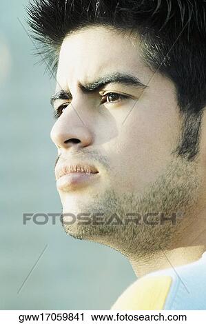 Close-up of a young man looking serious View Large Photo Image Stock Image - Close-up of a young man looking serious. Fotosearch