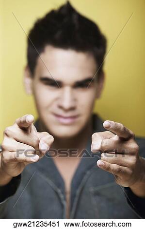 Close-up of a young man pointing forward View Large Photo Image Stock Image - Close-up of a young man pointing forward. Fotosearch