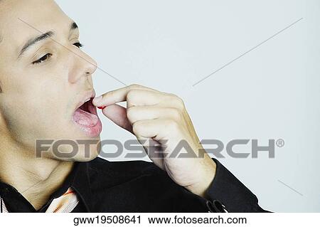 Close-up of a young man taking a pill View Large Photo Image Stock Image - Close-up of a young man taking a pill. Fotosearch