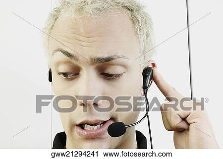 Close-up of a young man wearing headset and talking View Large Photo Image Stock Image - Close-up of a young man wearing headset and talking. Fotosearch