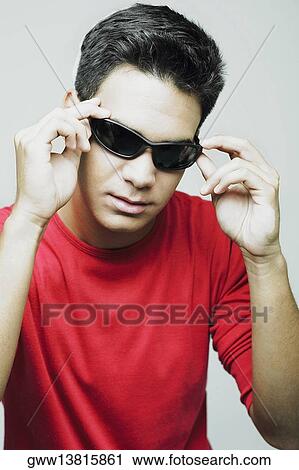 Close-up of a young man wearing sunglasses View Large Photo Image Stock Image - Close-up of a young man wearing sunglasses. Fotosearch